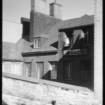 Rue St-Paul, 1932. Clifford M. Johnston / Bibliothèque et Archives Canada / PA-056553 A droite, on aperçoit une petite fille au balcon et l'enseigne de Philéas Lachance, plombier, 163-167 St-Paul.
